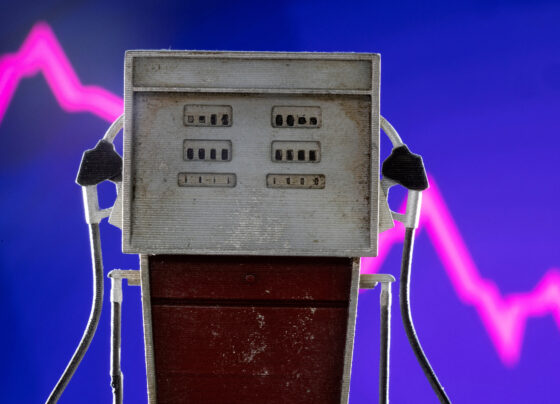 Model of petrol pump is seen in front of decreasing stock graph in this illustration. REUTERS/Dado Ruvic/Illustration